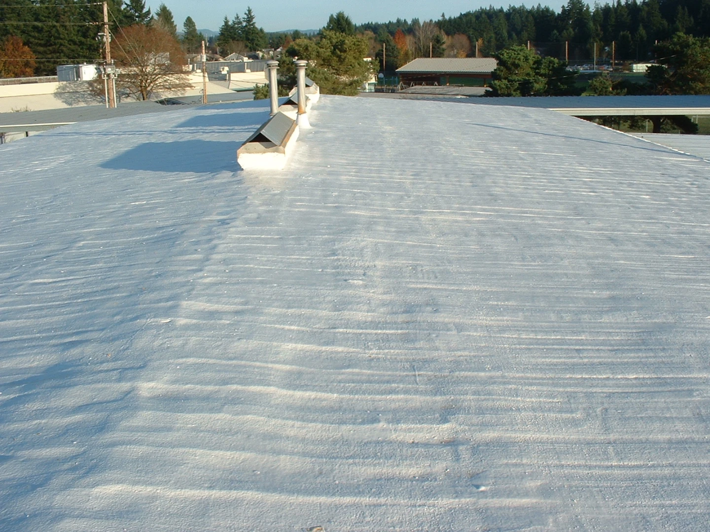 How Waterproof Topcoats Protect Spray Foam Roofing Systems